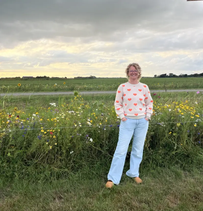 Joyce Zuidema tussen de wilde bloemen langs het weiland